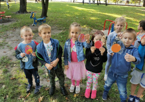 Dzieci poszukują poukrywanych kropek w ogrodzie przedszkolnym